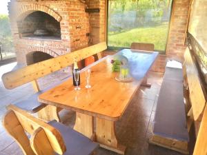 un tavolo in legno con sedie e un forno in mattoni di Rural holiday house Vinodol-Kalnik a Kalnik