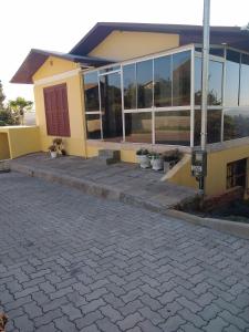 a yellow building with potted plants in front of it at Casa Temporada Monte Belo do Sul in Monte Belo