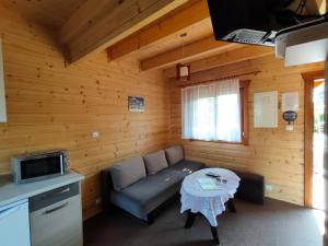 uma sala de estar com um sofá e uma mesa em Domki Letniskowe Promyk em Ustka