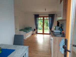 a room with a kitchen and a bedroom with a bed at Zimmervermietung Schnackenberg in Vollersode