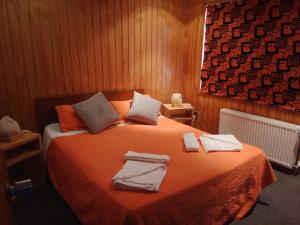 a bedroom with a bed with towels on it at ALMER HOSTAL in Punta Arenas