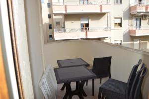 a table and chairs on a balcony with a building at La Stella di Gallipoli in Gallipoli
