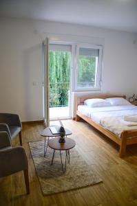 a bedroom with a bed and a table and a window at Central park in Vrdnik