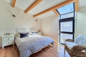 1 dormitorio con cama y ventana en La casita de Singulis, en Cangas de Morrazo
