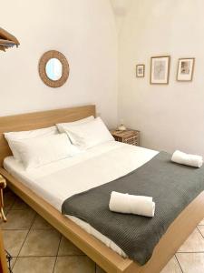 1 dormitorio con 1 cama grande y 2 toallas. en Charming apartment close to the Piazza, en Volterra