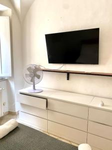 Zimmer mit einem TV an der Wand und einem Ventilator in der Unterkunft Charming apartment close to the Piazza in Volterra