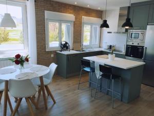 a kitchen with a table and some chairs and a kitchen with a counter at Precioso apartamento en Pamplona junto al centro in Pamplona