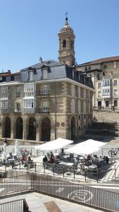 a large building with people sitting at tables in front of it at Hostal del Arquitecto in Vitoria-Gasteiz