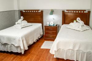 two beds with swans on them in a bedroom at Buen Retiro Apart Hotel in Santa Cruz de la Sierra