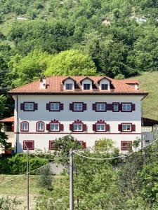 a large white building with a red roof at Large villa for 20 guests on large estate with private pool and tennis court Big conference room with facilities VILLAITALY EU in Cairo Montenotte