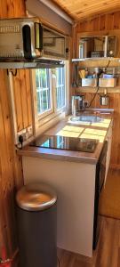 a small kitchen with a stove and a counter top at Small Cozy Shepherd hut 20 by 7 feet with boxed in high double bed in Balmacara