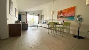 - un salon avec une table et des chaises vertes dans l'établissement Apartamento Moradias, à Santa Maria
