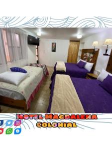 two beds in a room with purple sheets at Hotel Magdalena Colonial in Guanajuato