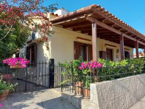 a house with a fence and pink flowers at Elisavet's House in Platanias