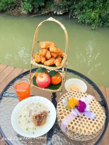 stół z talerzem żywności i kosz żywności w obiekcie Aree Garden Home Private Homestay by the Waterfall Chantaburi - บ้านสวนพลิ้วอารี ริมธารน้ำตกพลิ้ว จันทบุรี 