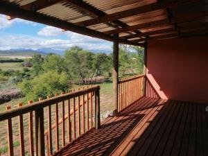 uma varanda de uma casa com vista para um campo em Cango's Rest em Oudtshoorn