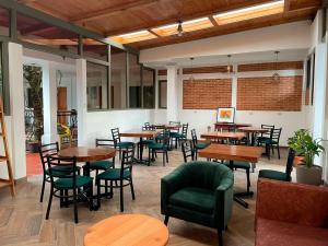 a restaurant with wooden tables and green chairs at Matalbatz Hotel in Cobán