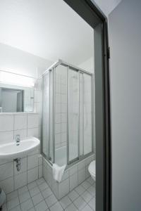 a bathroom with a shower and a sink and a toilet at Hotel Christina in Cologne