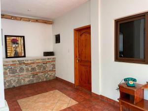 a living room with a television and a stone fireplace at Matalbatz Hotel in Cobán