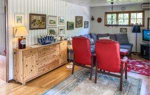 Stunning Home In Gamleby With Kitchen في Gamleby: غرفة معيشة مع أريكة وطاولة وكراسي حمراء