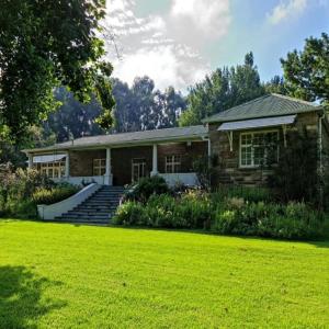 a brick house with a lawn in front of it at House at Glengariff in Underberg
