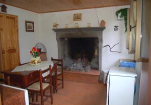 Una sala de estar con chimenea y una mesa y sillas. en Il Molino, en Bagni di Lucca