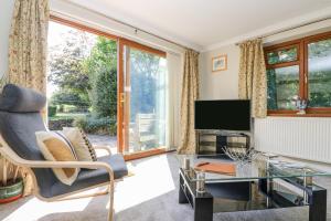 a living room with a television and a glass table at Manege Cottage in Chacewater