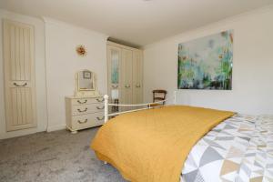 a bedroom with a bed and a painting on the wall at Manege Cottage in Chacewater