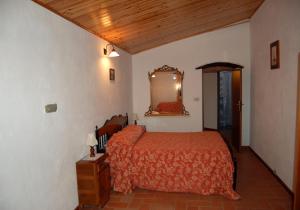 Un dormitorio con una cama y un espejo en la pared. en Il Molino, en Bagni di Lucca