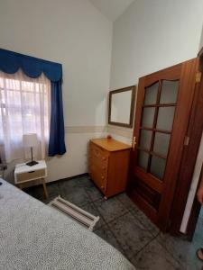 Schlafzimmer mit einem Bett, einer Kommode und einem Spiegel in der Unterkunft Mi Jardin in Frontera