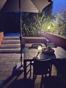 a wooden table with an umbrella on a patio at bij Petros in Opglabbeek