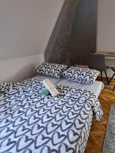 a bed with a black and white comforter and a chair at Apartman Filip Novi Sad in Novi Sad