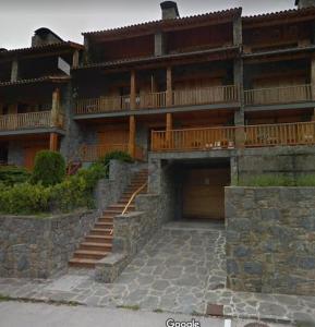 uma casa grande com uma escada de pedra em frente em Can Tersi em Setcases