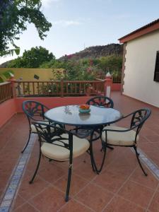 einen Tisch und Stühle auf einer Terrasse in der Unterkunft Mi Jardin in Frontera