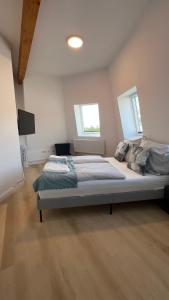ein großes Bett in einem Zimmer mit zwei Fenstern in der Unterkunft My Apartment im Bremer Viertel in Bremen