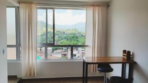 Zimmer mit einem Tisch und einem großen Fenster in der Unterkunft Lagom Apartamentos San Rafael in San Rafael