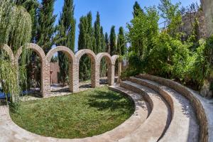 a garden with arches and grass and trees at Castle in Old Town in Tbilisi City