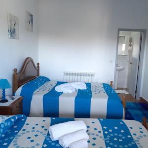 two beds in a room with blue and white at O Caçador in Vila Chã de Braciosa +21 photos