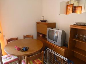 マリネッラ・ディ・サルザーナにあるAppartamento Villa Ileanaのテーブルとテレビ付きの小さな部屋