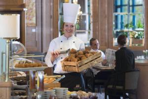 a man in a chef's outfit cutting a cake at Maritim Airport Hotel Hannover in Hannover