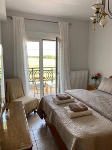 a bedroom with two beds and a balcony at Polys Apartment and Paraskevi studio with view in Ptolemaida