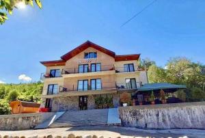 un grande edificio con una scala di fronte di Hotel Mountain Mestia a Mestia