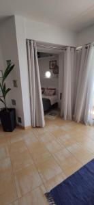 sala de estar con cama, cortinas y suelo de baldosa. en Beach4you - Sesimbra, en Sesimbra