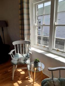 um quarto com uma cadeira, uma mesa e uma janela em Ballymultimber Cottages em Limavady