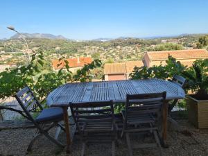 einen Tisch und Stühle auf einem Balkon mit Aussicht in der Unterkunft Bas de villa T3 Ollioules avec Piscine Vue mer in Ollioules
