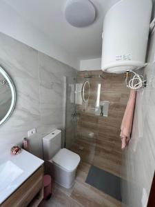 een badkamer met een toilet, een wastafel en een spiegel bij ÁTICO VISTA TEIDE in Arona +13 foto's