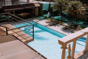 una vista aérea de una piscina con sillas y una escalera en Hotel Vista De Golf, San Jose Aeropuerto, Costa Rica en San José