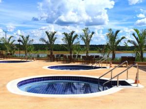 a swimming pool with a table and chairs and a lake at Resort Praias do Lago in Caldas Novas +17 photos