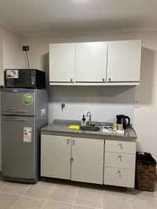 eine Küche mit weißen Schränken und einem Kühlschrank in der Unterkunft Departamento en zona centro in Resistencia