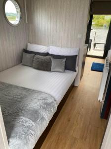 a large bed in a small room with a window at Couston Lakes Resorts in Bathgate